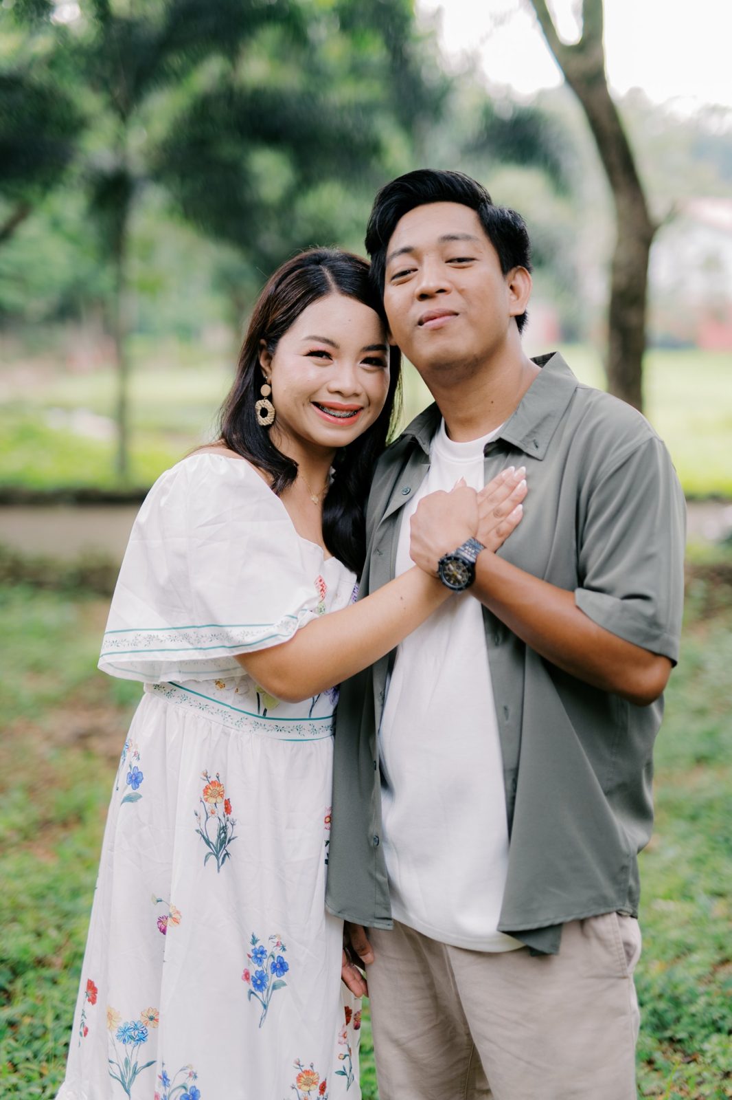 Regine and Arnaldo smiling cheek to cheek in a garden, holding hands over his heart